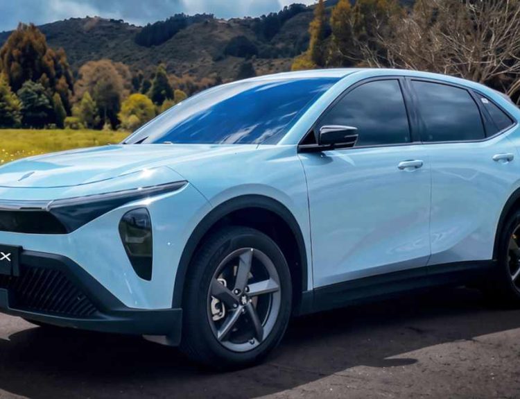Plano frontal de tres cuartos de la SUV eléctrica JMEV GSX color azul celeste estacionada en un entorno campestre, destacando su franja LED superior y faros principales divididos.