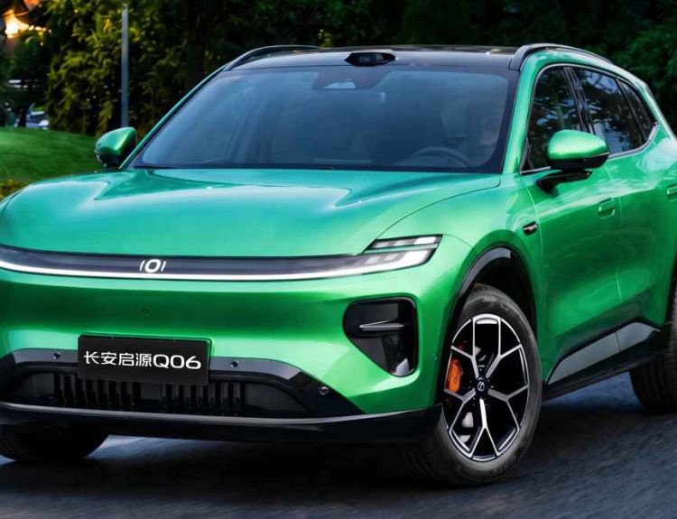 Plano frontal de tres cuartos de la SUV Changan Nevo Q06 verde circulando por una vía rodeada de vegetación, destacando su franja luminosa LED, sensor LiDAR en el techo y rines bitono con mordazas naranjas.