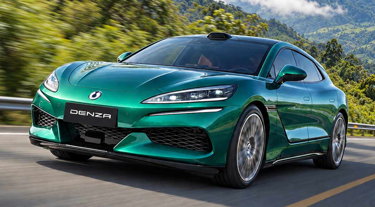 Plano frontal de tres cuartos del deportivo familiar Denza Z9 GT verde rodando a velocidad por una autopista rodeada de bosque, destacando su carrocería tipo shooting brake, faros afilados y silueta aerodinámica.