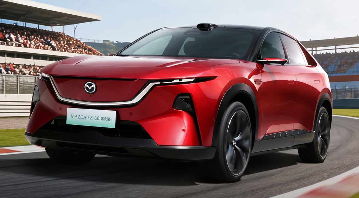 Plano frontal de tres cuartos de la SUV Mazda CX-6e (EZ-60) roja circulando por una pista de carreras, destacando su silueta aerodinámica, luces diurnas afiladas y la parrilla frontal cerrada.