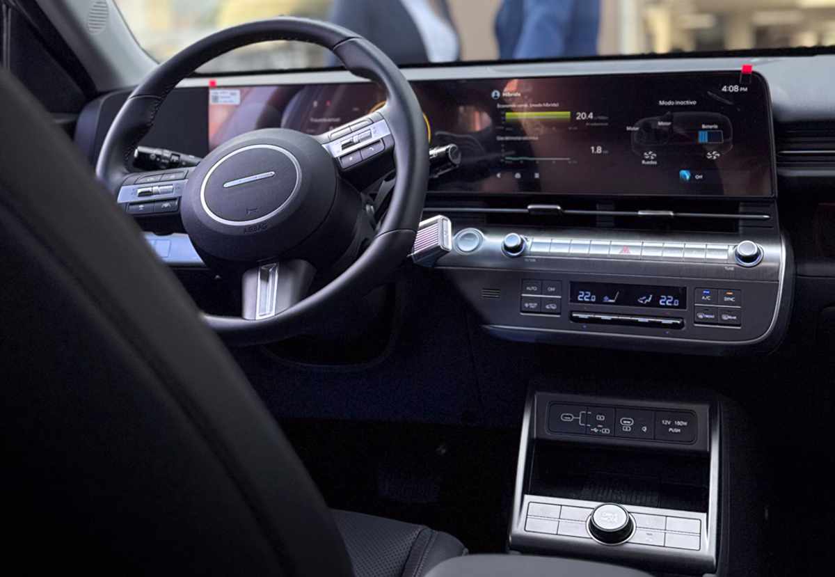 Plano detalle del tablero interior de la Hyundai Kona Híbrida, mostrando el puesto de conducción con la pantalla central táctil de 12,3 pulgadas encendida y el moderno volante multifuncional.