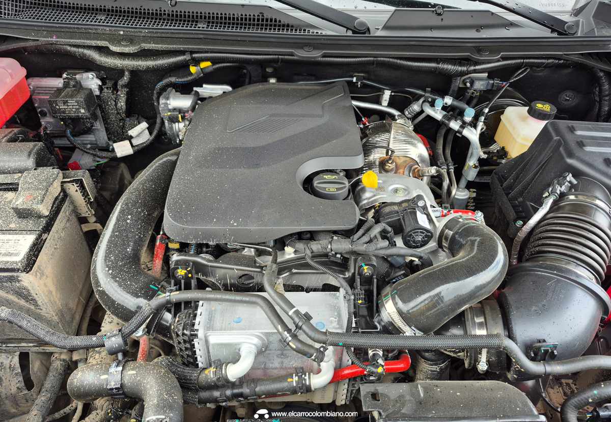 Plano detalle del compartimento del motor abierto de la RAM Dakota, mostrando el bloque Multijet Turbodiésel de 2.2 litros desarrollado por Stellantis, cubierto por su tapa plástica protectora.