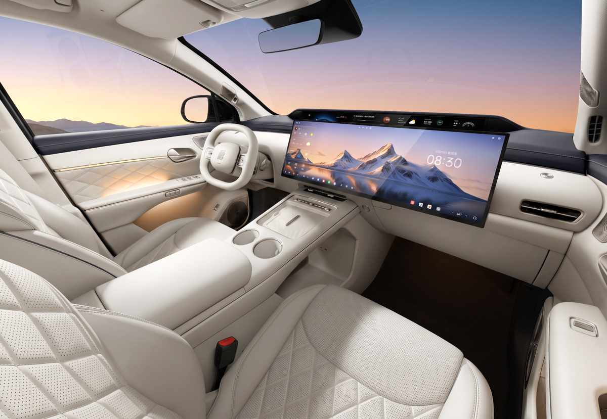 Plano general del interior de la BYD Tang en color beige, resaltando la enorme pantalla panorámica continua sobre el tablero, volante claro y asientos de cuero con costuras de rombos.
