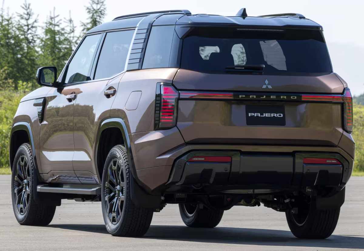 Plano de tres cuartos trasero de la nueva Mitsubishi Montero color café bronce con techo negro, mostrando sus luces LED verticales conectadas y el portón trasero con molde hexagonal.